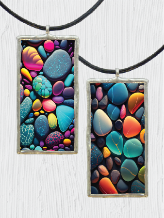 Colorful pebble-patterned pendant on a black cord against a white background
