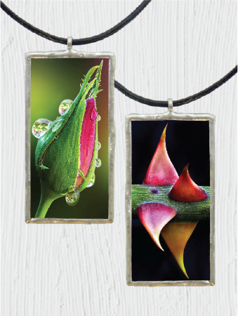 Two rectangular pendant necklaces with floral rose and thorn design on a white background
